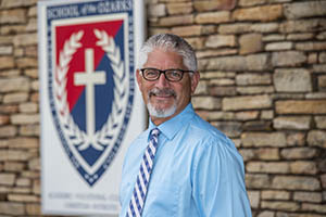 Man in front of rock wall.